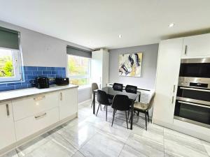 a kitchen with a table and chairs in a room at Lovely 3 bedroom Apartment By Sensational Stay Short Lets & Service Accommodation with 6 beds in Edinburgh