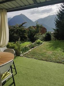 a patio with a table and chairs and mountains in the background at Apartment Lilija in Bovec