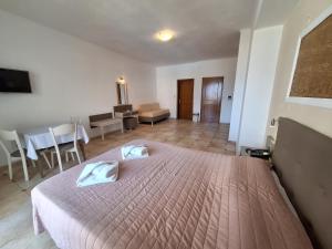 a bedroom with a bed and a living room at Perla Beach in Agia Marina Nea Kydonias