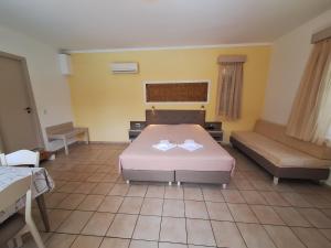 a hotel room with a bed and a couch at Perla Beach in Agia Marina Nea Kydonias