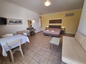 a room with a bed and a table and a couch at Perla Beach in Agia Marina Nea Kydonias
