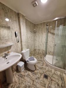 a bathroom with a toilet and a sink and a shower at Perla Beach in Agia Marina Nea Kydonias