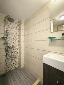 a bathroom with a sink and a shower at Neva Apartments by the Beach in Makry Gialos