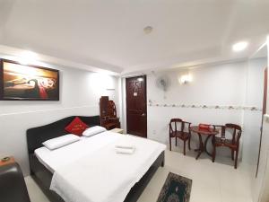 Schlafzimmer mit einem Bett, einem Tisch und Stühlen in der Unterkunft OYO 1226 Hoang Gia Hotel in Ho-Chi-Minh-Stadt