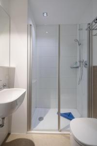 a bathroom with a shower and a toilet and a sink at Ferienhaus Haus an der Mühle in Norderney