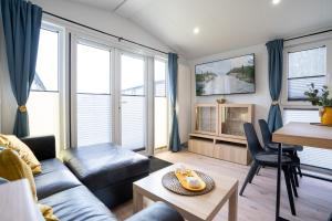 ein Wohnzimmer mit Sofa und Tisch in der Unterkunft Ostseecamp Ferienhaus "Sonneneck" mit umzäuntem Grundstück in Scharbeutz