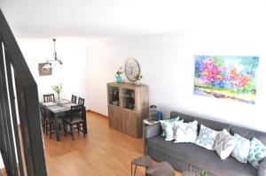 ein Wohnzimmer mit Couch und ein Esszimmer in der Unterkunft Ático Dúplex en Delta de l'Ebre dos terrazas y balcón in Deltebre