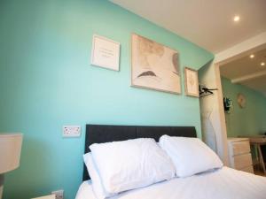 a bedroom with a blue wall and a bed with white pillows at Pass the Keys Cathedral View Apartment Two in Lincoln