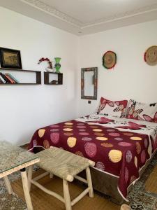 1 dormitorio con 1 cama y 1 mesa en Dar Doukkala Oualidia, en Oualidia