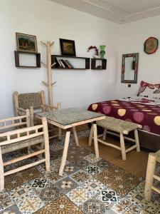 Schlafzimmer mit einem Bett, einem Tisch und Stühlen in der Unterkunft Dar Doukkala Oualidia in Oualidia