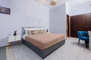 a bedroom with a bed and a blue chair at GIN Wellness Hotel in Pyrgos