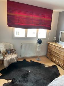 een slaapkamer met een rood gordijn en een zwart tapijt bij Coquet appartement in Turckheim