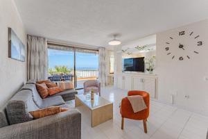een woonkamer met een bank en een klok bij Great Apartment in Los Gigantes in Acantilado de los Gigantes
