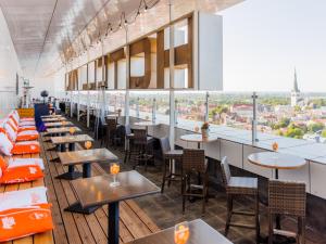 a restaurant with tables and chairs and a view of the city at Original Sokos Hotel Viru in Tallinn