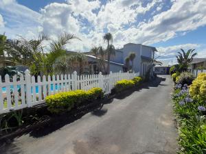 a white picket fence in front of a house at Sea Breeze Shelly Beach in Shelly Beach
