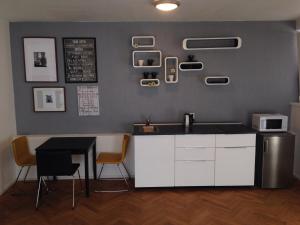 a kitchen with a sink and a table with chairs at James Hotel & Apartments in Prague