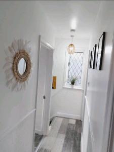 a white hallway with a mirror and a window at COSY AND PRIVATE HOUSE CLOSE TO TOWN in Manchester