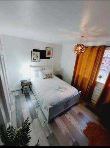 a bedroom with a white bed and a window at COSY AND PRIVATE HOUSE CLOSE TO TOWN in Manchester