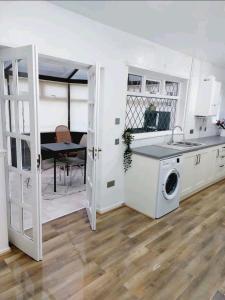 a kitchen with a sink and a washing machine at COSY AND PRIVATE HOUSE CLOSE TO TOWN in Manchester
