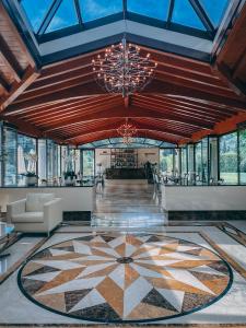 ソイアーノ・デル・ラーゴにあるMonastero Resort & Spa - Garda Lake Collectionの大きな天井とシャンデリアのあるオープンロビー