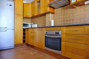 - une cuisine avec des placards en bois et un réfrigérateur blanc dans l'établissement Casa Magda and Luke, à La Cala de Mijas