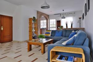 - un salon avec un canapé bleu et une table dans l'établissement Casa Magda and Luke, à La Cala de Mijas