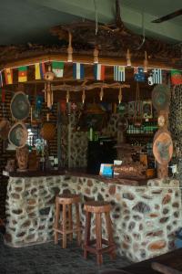 a bar with two stools in a room with a stone wall at Sumatra Orangutan Treks Villa in Timbanglawang
