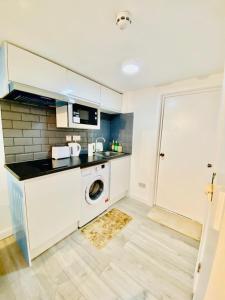 a kitchen with a washing machine and a washer at One Bedroom Apartment Wembley Stadium in London in London