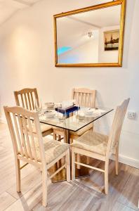 a dining room table with two chairs and a mirror at One Bedroom Apartment Wembley Stadium in London in London