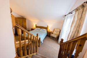 a bedroom with a bed and a staircase with a stair case at Pine Cottage Little Haven in Little Haven