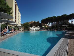 a large swimming pool with chairs and umbrellas at Hotel Colorado Cesenatico in Cesenatico