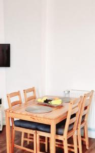 a wooden table with four chairs around it at City Studio Apartment for 4, near Sonnenallee in Berlin