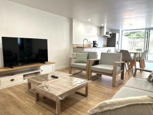 een woonkamer met een grote flatscreen-tv bij Maison des années 1920 - à 150 m de l'océan et proche des commodités - 4 logements indépendants in Saint-Jean-de-Monts