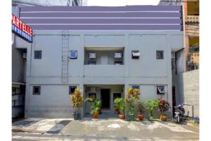 a white building with potted plants in front of it at OYO 1069 Cittatel Inn in Manila