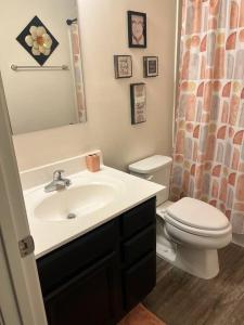 a bathroom with a white sink and a toilet at Cozy Nest: Where Love Blossoms in Nashville