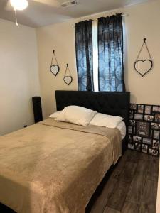 a bedroom with a bed and a window with curtains at Cozy Nest: Where Love Blossoms in Nashville