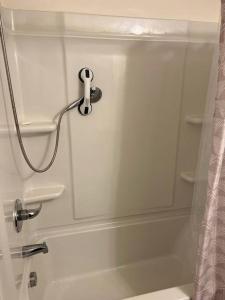 a bath tub with a shower curtain and a shower head at Cozy Nest: Where Love Blossoms in Nashville