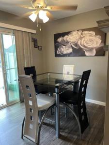 a dining room table with chairs and a painting of roses at Cozy Nest: Where Love Blossoms in Nashville