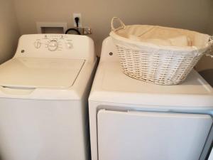 a laundry basket sitting on top of a washer and dryer at Cozy Nest: Where Love Blossoms in Nashville