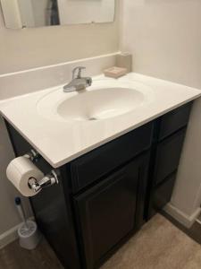 a bathroom with a white sink and a mirror at Cozy Nest: Where Love Blossoms in Nashville