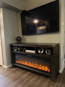 a living room with a fireplace with a tv above it at Cozy Nest: Where Love Blossoms in Nashville