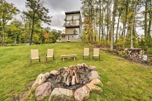 a fire pit with chairs and a house in the background at Tower Lake Vacation Home & Cabin in Birchwood