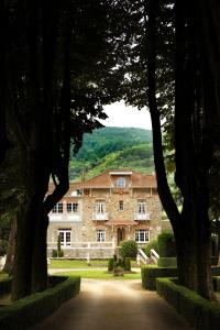Lacabarède的住宿－德穆芙蓉酒店，一座大石头房子前面有树木