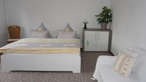 a bedroom with a large bed and a chair at Ferienwohnung Havelnixe in Bahnitz
