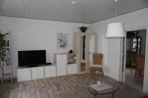 a living room with a flat screen tv on a cabinet at Ferienwohnung Havelnixe in Bahnitz