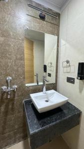 ein Bad mit einem Waschbecken und einem Spiegel in der Unterkunft Exotic studio in Ghaziabad