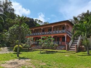 a house with a balcony and palm trees at Matahari Long Beach in Perhentian Islands