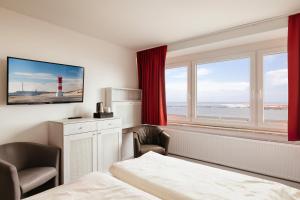 ein Hotelzimmer mit einem Bett und einem Fenster mit einem Leuchtturm in der Unterkunft Hotel Felsen-Eck in Helgoland