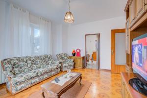 un soggiorno con divano e TV di Zio Enry Terrace Apartment Orta Lake - Happy Rentals ad Armeno