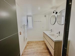 een badkamer met een wastafel en een spiegel bij Maison des années 1920 - à 150 m de l'océan et proche des commodités - 4 logements indépendants in Saint-Jean-de-Monts +78 foto's